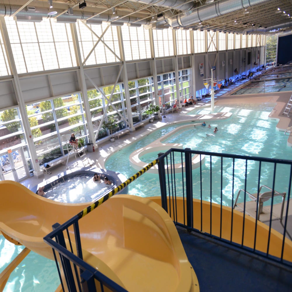 View of a large indoor swimming pool from the top of a water slide.