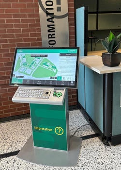 A digital touchscreen kiosk sits beside a sign that reads "information." On the screen is a map of the SciTech campus highlighting different buildings.